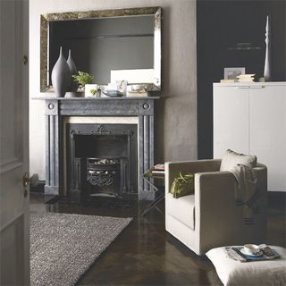 living area with moody grey wall and fireplace and arm chair