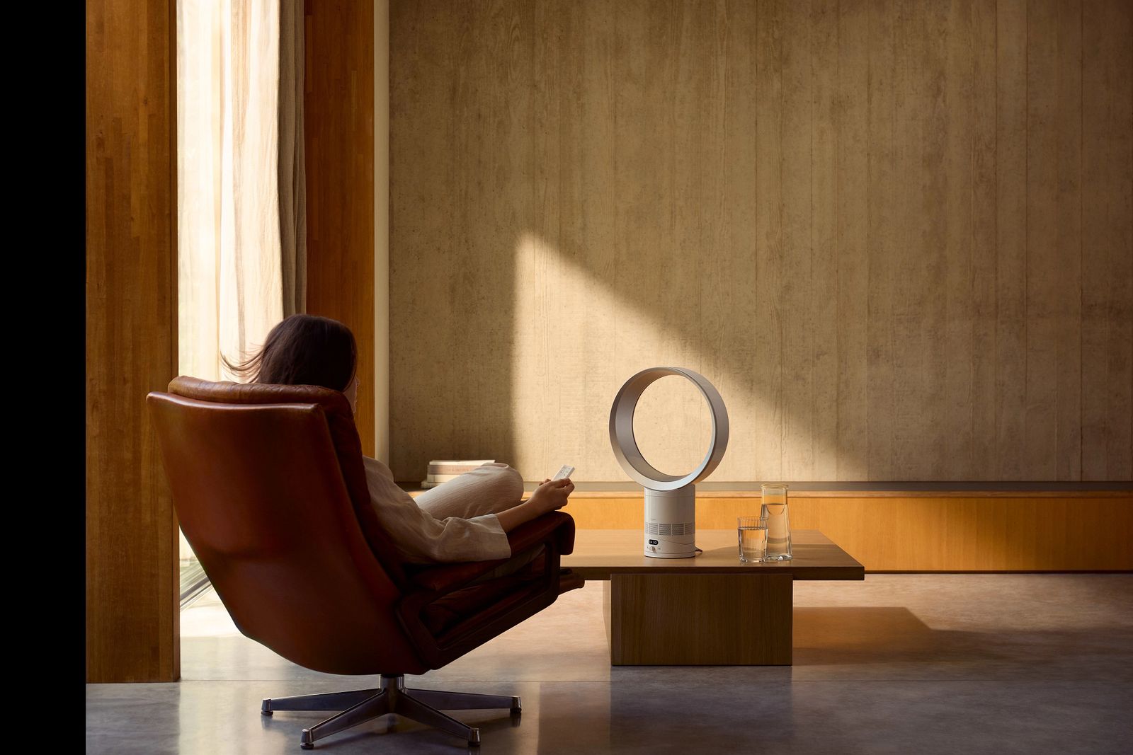 Person in chair, facing a Dyson fan on coffee table