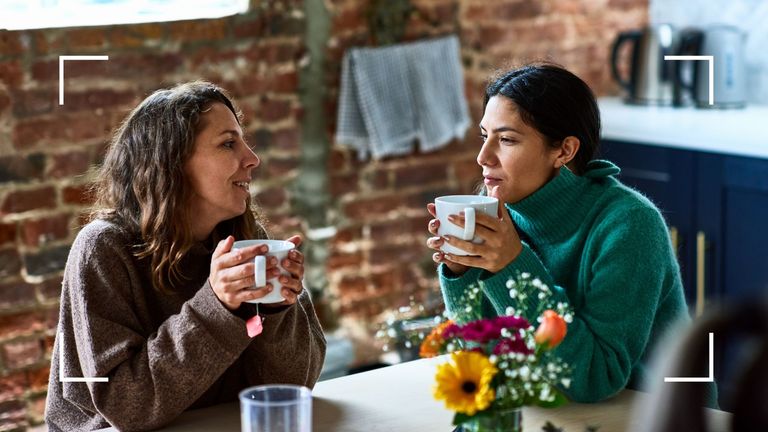 Two women talking holding mugs over breakfast table, to illustrate how to support someone with depression