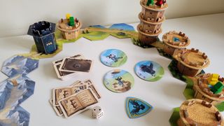 Wandering Towers components, cards, and tiles on a white surface