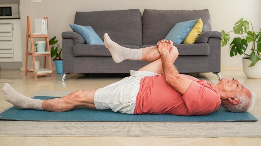 a senior man lying on an exercise mat 
