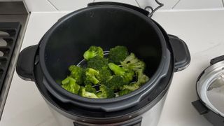 Crock-Pot Express filled with brocolli on a kitchen countertop