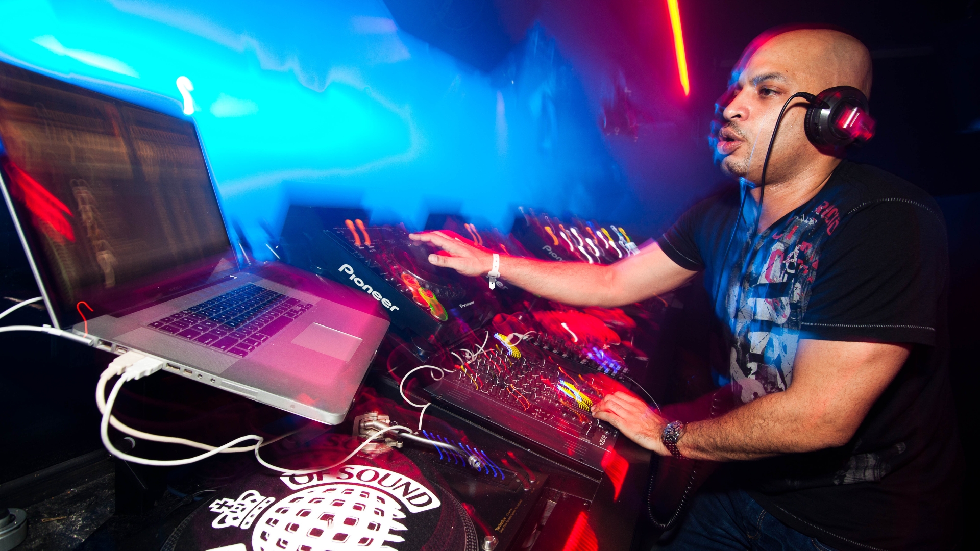 A man DJs on stage with a laptop