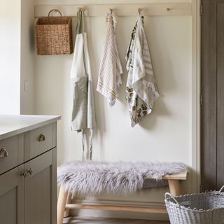 Hallway in barn conversion with wooden bench and wooden coat hooks