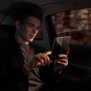 Man in a car using an HONOR Magic Vs smartphone