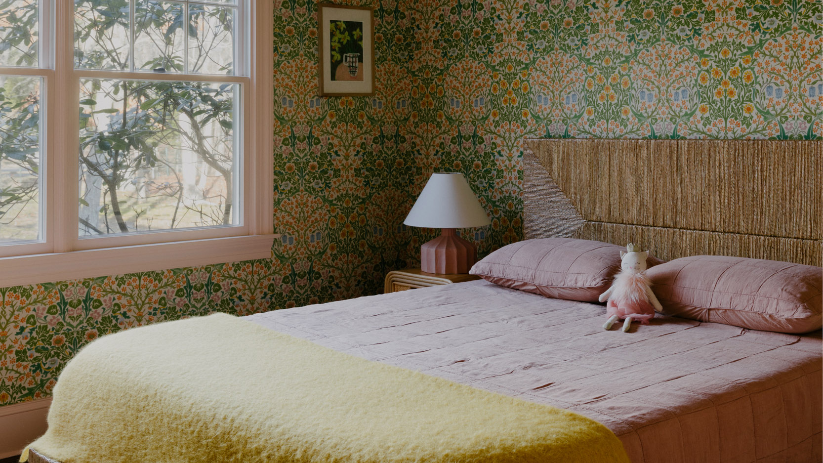 kid's bedroom with green patterned wallpaper and large bed with a toy in the middle of it