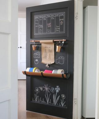 A door organizer decorated with black chalkboard paint with lists and upcycled shelves