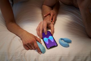 Couple using the We-Vibe Chorus vibrator in bed