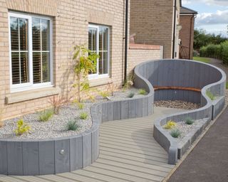 outdoor seating area in a front garden surrounded by curved timber walls