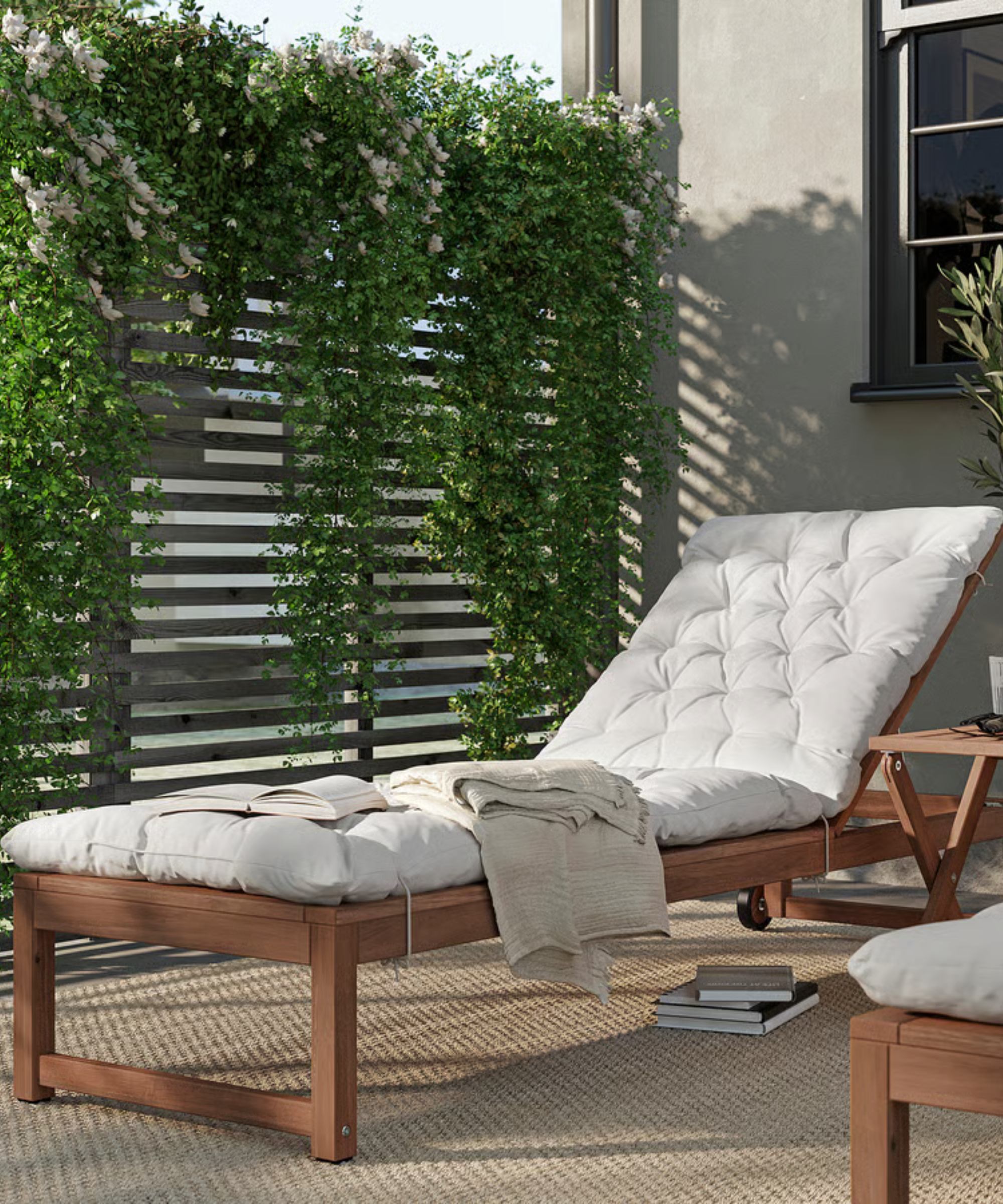 an acacia wood sun lounger with a white cushion in a backyard