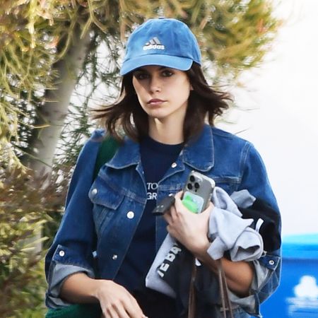 Kaia Gerber wearing a denim jacket and baseball cap