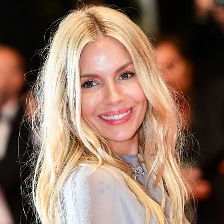 Sienna Miller smiles looking over her shoulder