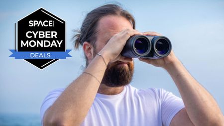 A person looking through the Canon 18x50 IS binoculars with a pale sky in the background with a black Space.com Cyber Monday badge in the upper-left corner.