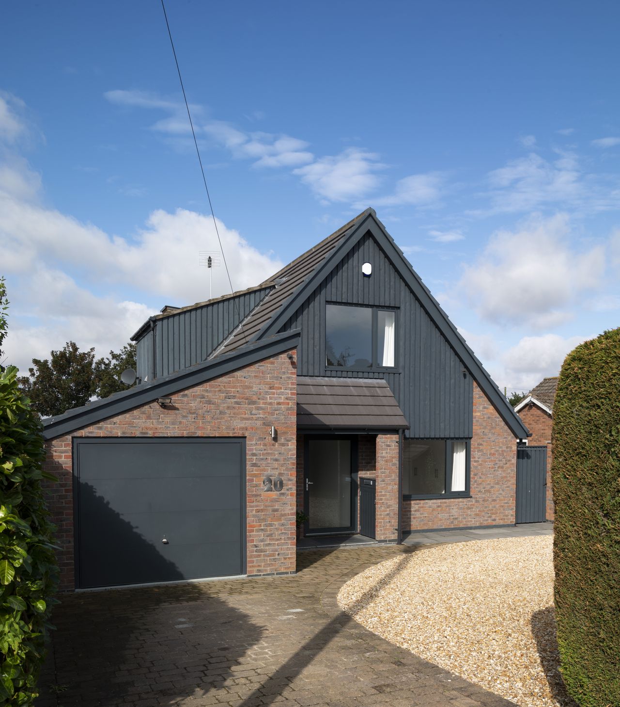The windows have been replaced with aluminium versions, the old timber cladding exchanged for vertical timber boarding and the facing bricks and stonework at the front of the house were taken off and rebuilt using new, more attractive facing bricks.