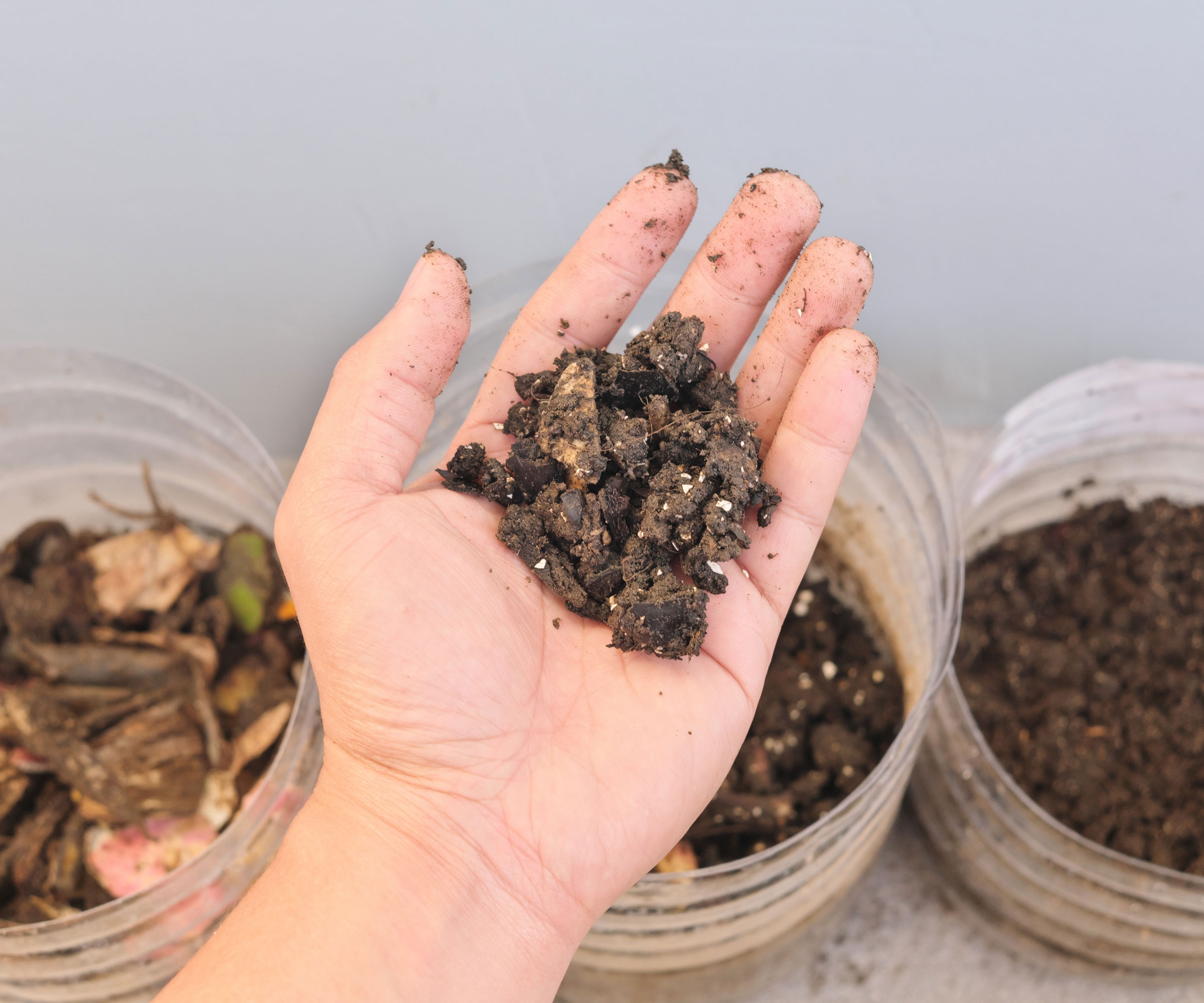 adding material to a DIY composting bin setup