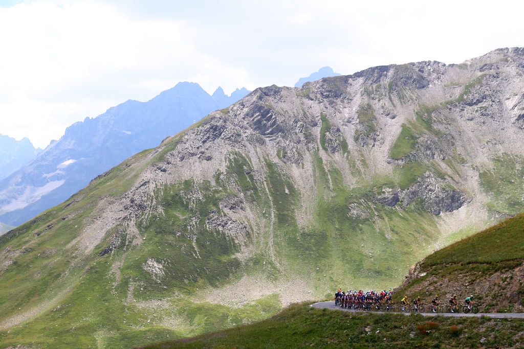ALPE DHUEZ FRANCE JULY 14 A general view of Wout Van Aert of Belgium Green Points Jersey Jonas Vingegaard Rasmussen of Denmark and Team Jumbo Visma Yellow Leader Jersey and the peloton compete beginning to climb the Col du Lautaret 2056m mountain landscape during the 109th Tour de France 2022 Stage 12 a 1651km stage from Brianon to LAlpe dHuez 1471m TDF2022 WorldTour on July 14 2022 in Alpe dHuez France Photo by Michael SteeleGetty Images