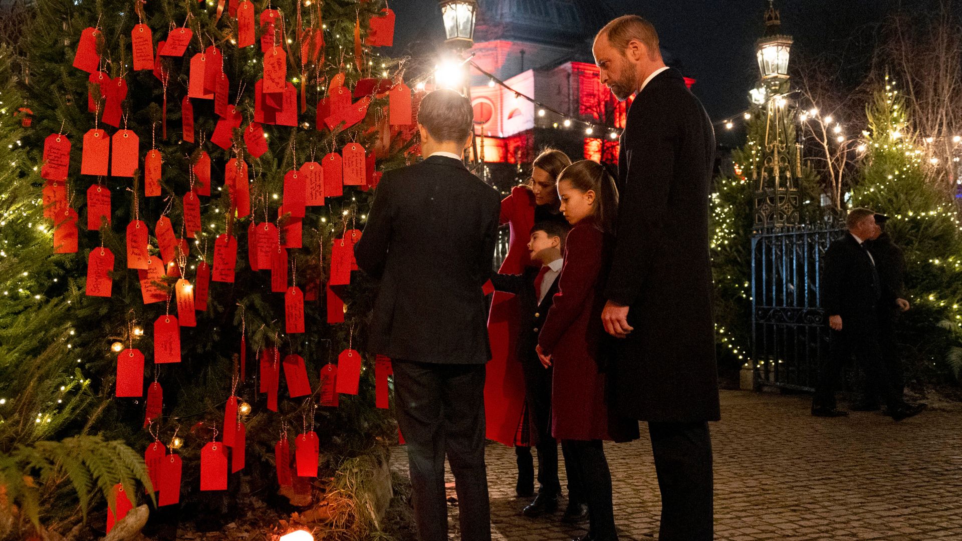 The Prince and Princess of Wales with their children Prince George, Princess Charlotte and Prince Louis look at messages on the Kindness Tree ahead of the Together At Christmas carol service at Westminster Abbey on December 6, 2024