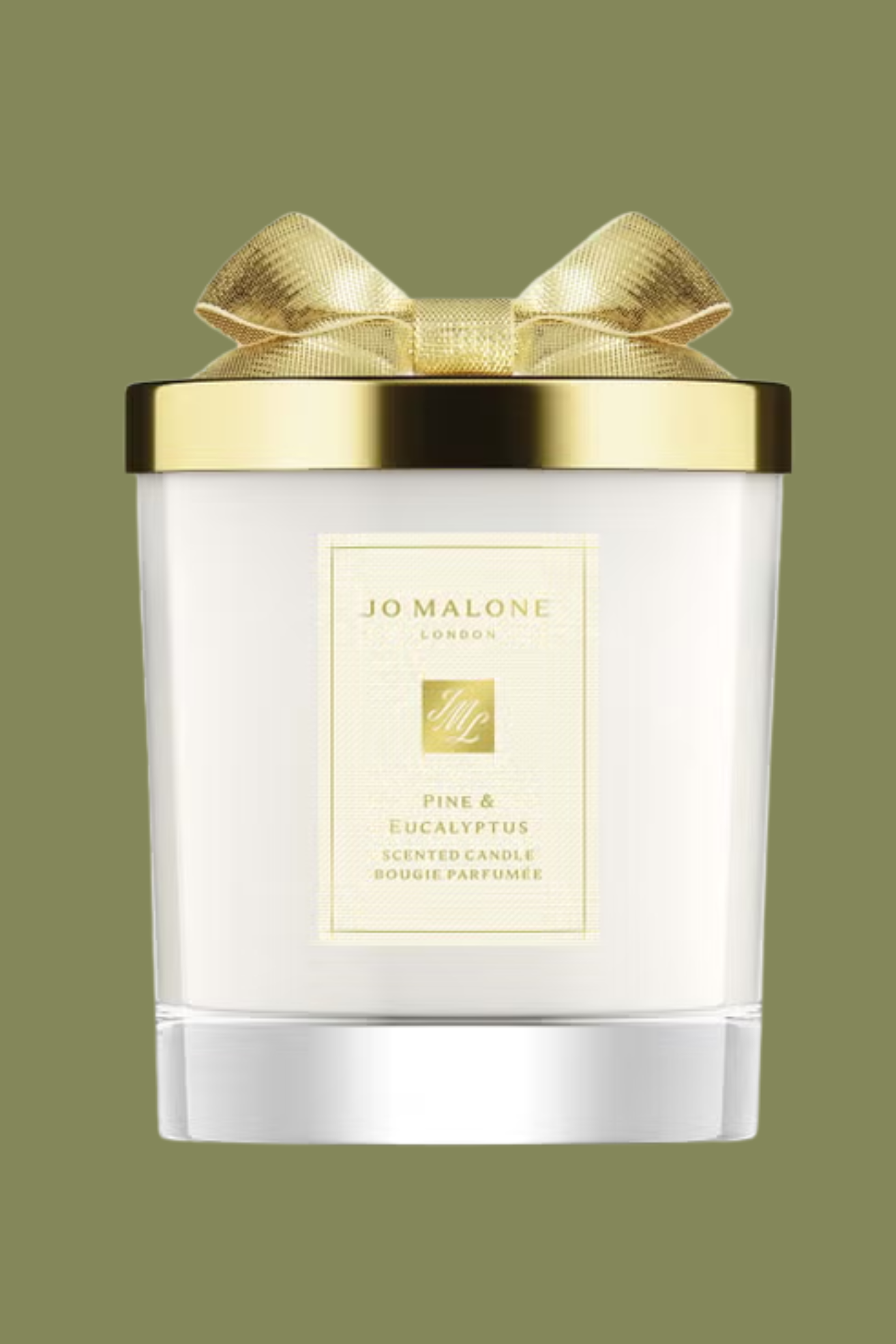 A glass candle with a gold lid and a bow