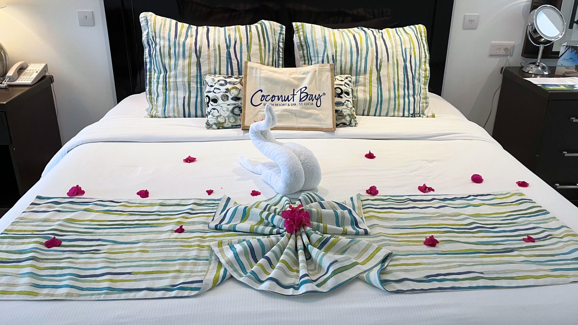 picture of freshly made bed with petals and towel animal