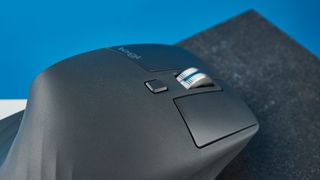 A photo of the Logitech MX Master 3S on a black slate against a blue background.