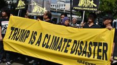 Greenpeace activists display a banner during a rally in front of the US embassy in Jakarta on June 7, 2017 following US President Donald Trump's decision to quit the Paris climate accord