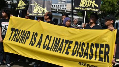 Greenpeace activists display a banner during a rally in front of the US embassy in Jakarta on June 7, 2017 following US President Donald Trump&#039;s decision to quit the Paris climate accord