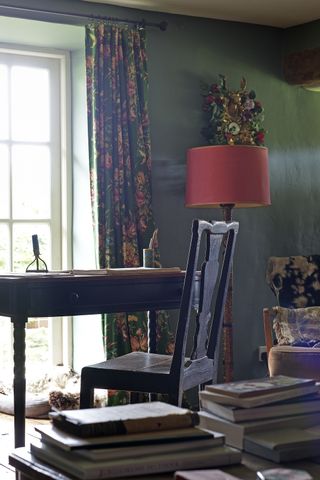 desk and chair in dark interior living room with red lamp