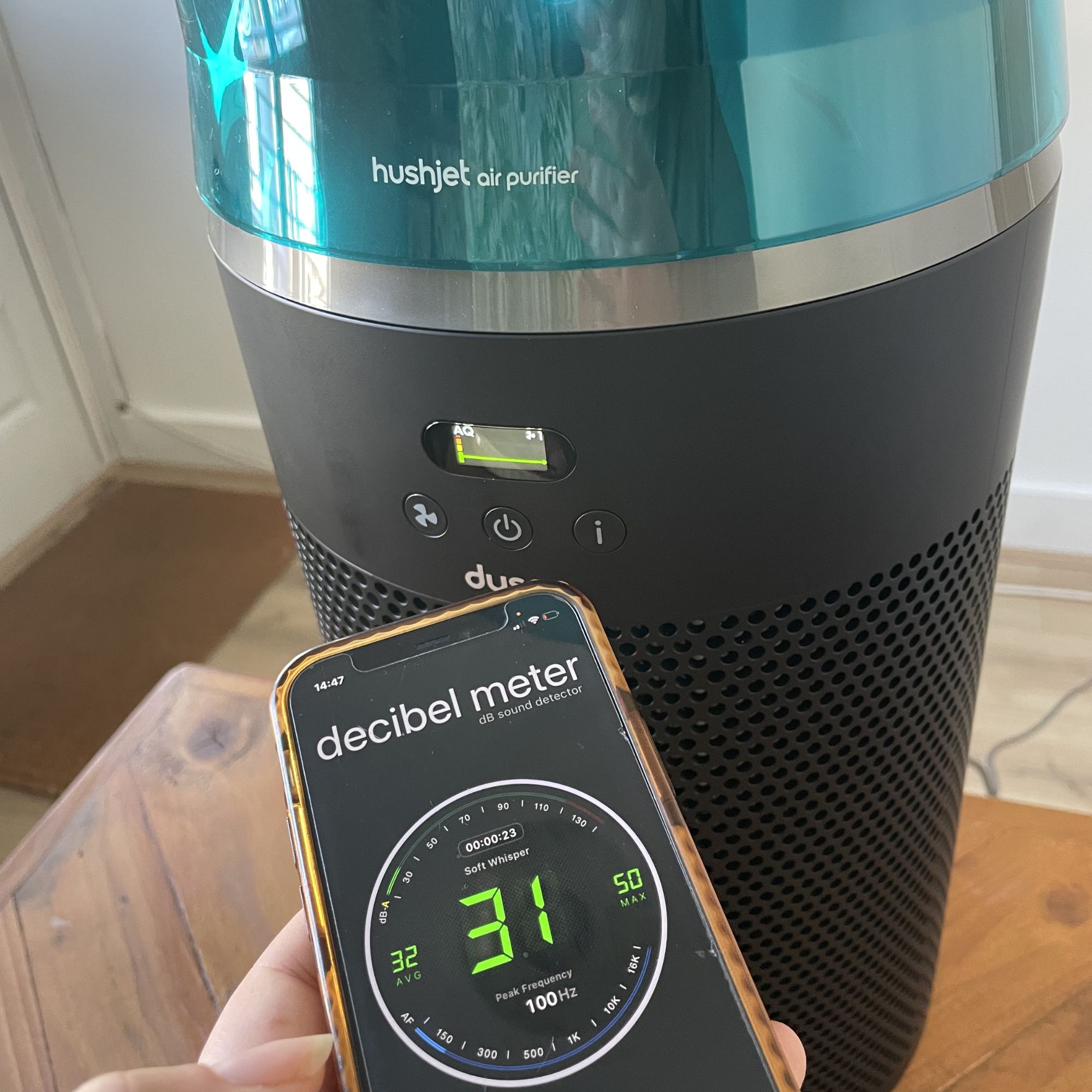 hand holding a phone with a decibel meter showing 31dB in front of the Dyson Hushjet Air Purifier