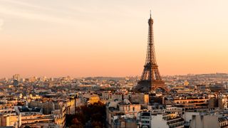 Aerial view of Paris streets and the Eiffel Tower at sunset.