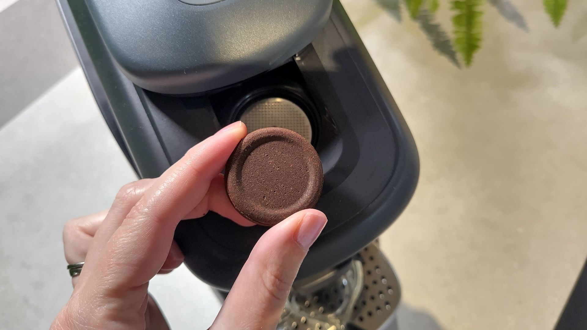 Person inserting coffee tab in Lavazza Tabli coffee machine