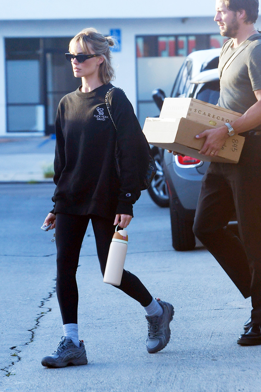 Margot Robbie wearing a sweatshirt, leggings, crew socks, and chunky sneakers