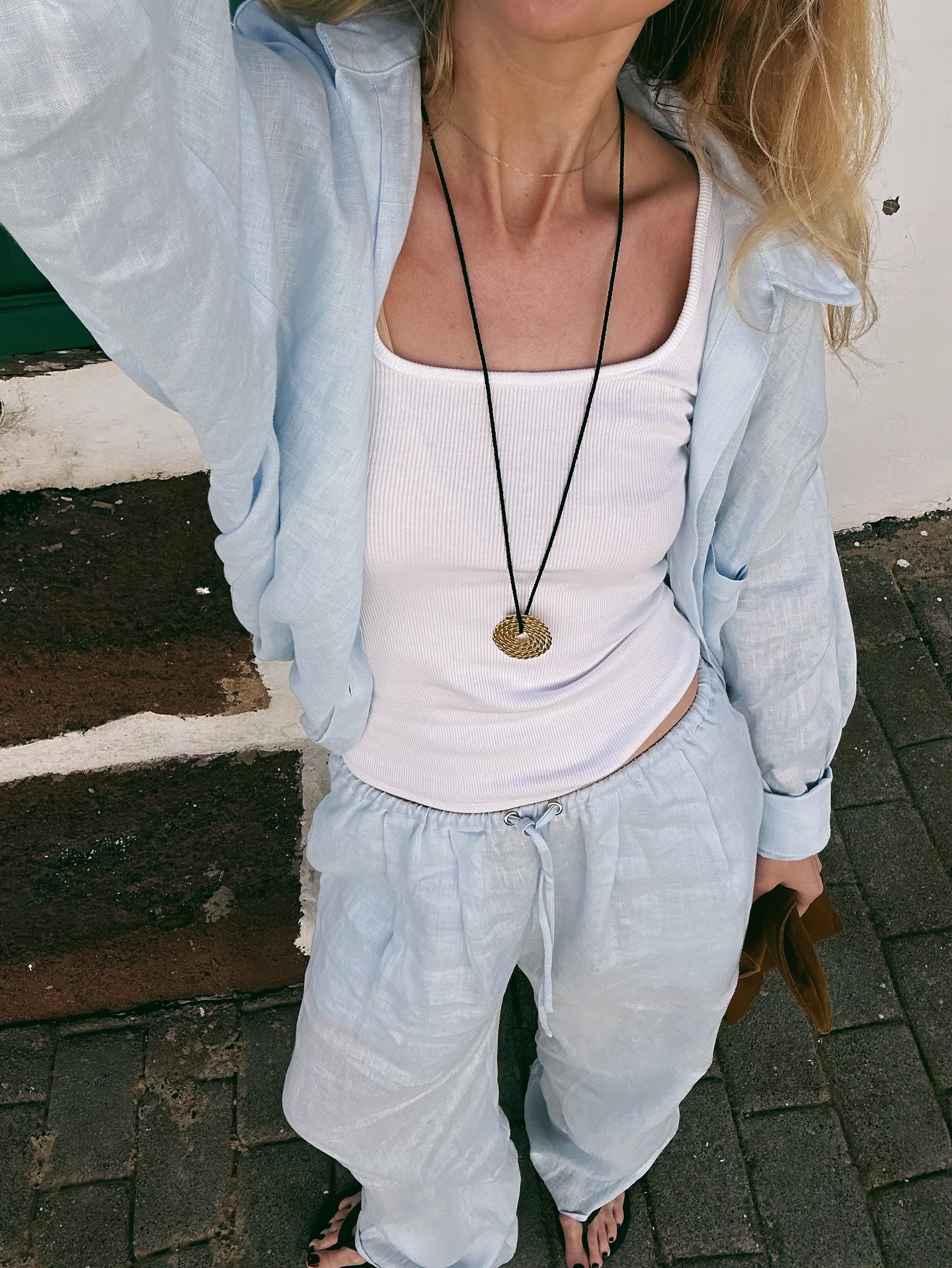 chloe kath butler wears a cotton vest, linen trousers and linen shirt