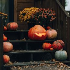 Chrysanthemums in a spooky porch display alongside carved Halloween pumpkins