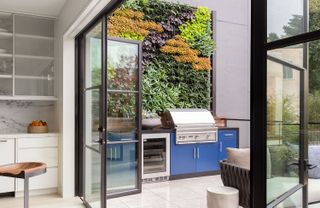 an outdoor kitchen with a living wall behind it