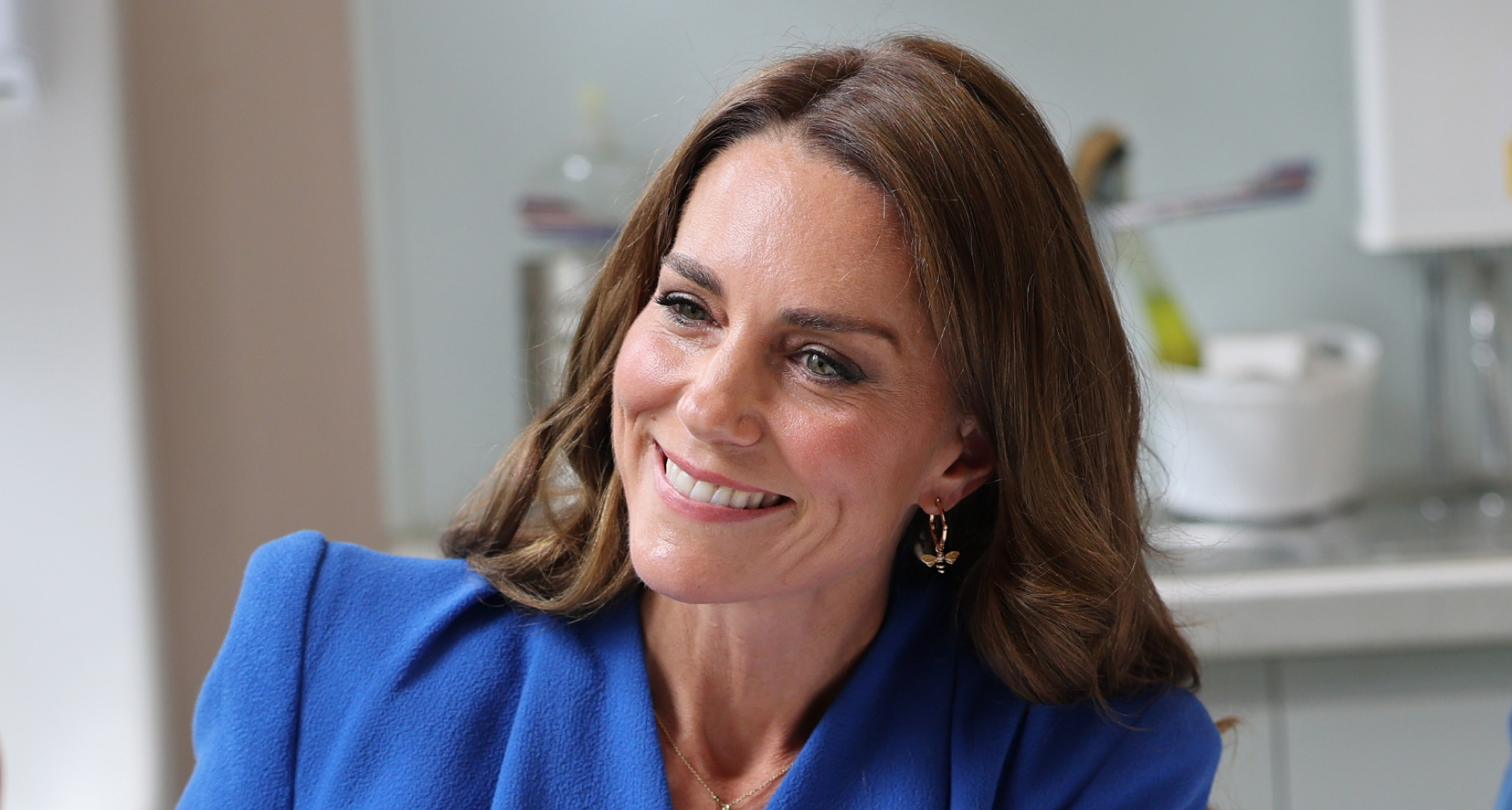 Princess Kate wearing a blue dress and smiling 