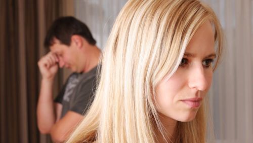 Blonde women with dark-haired man in background