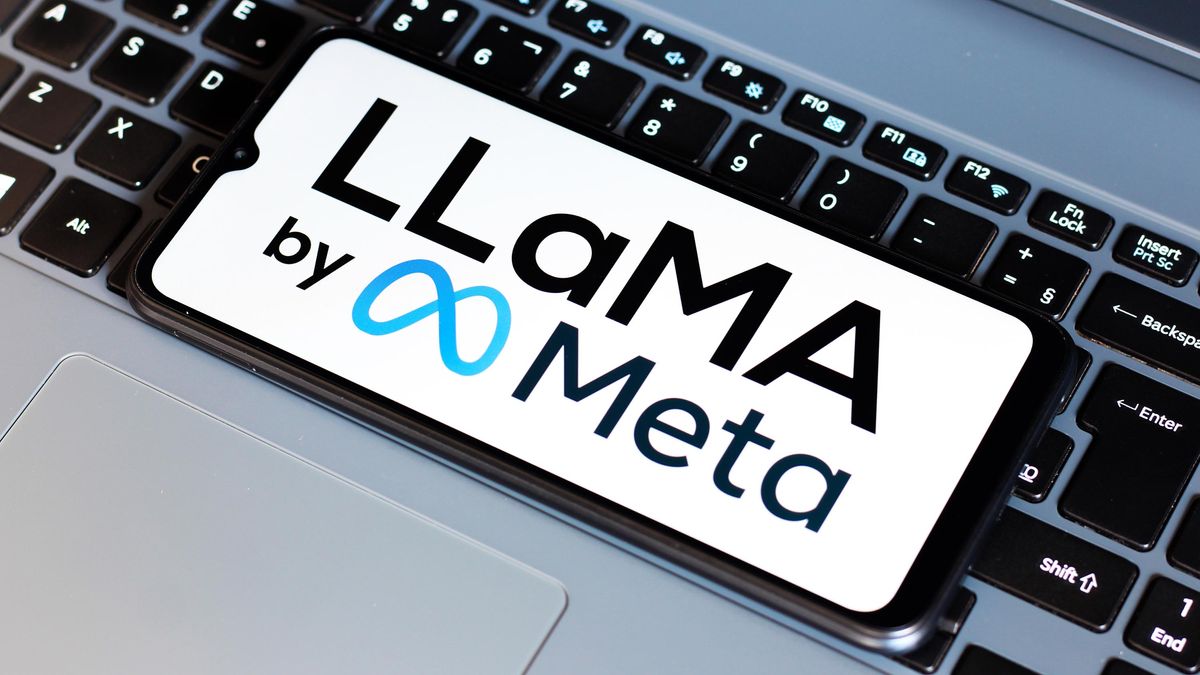 Text of LlaMA by Meta on a phone&#039;s display resting on a laptop&#039;s keyboard.