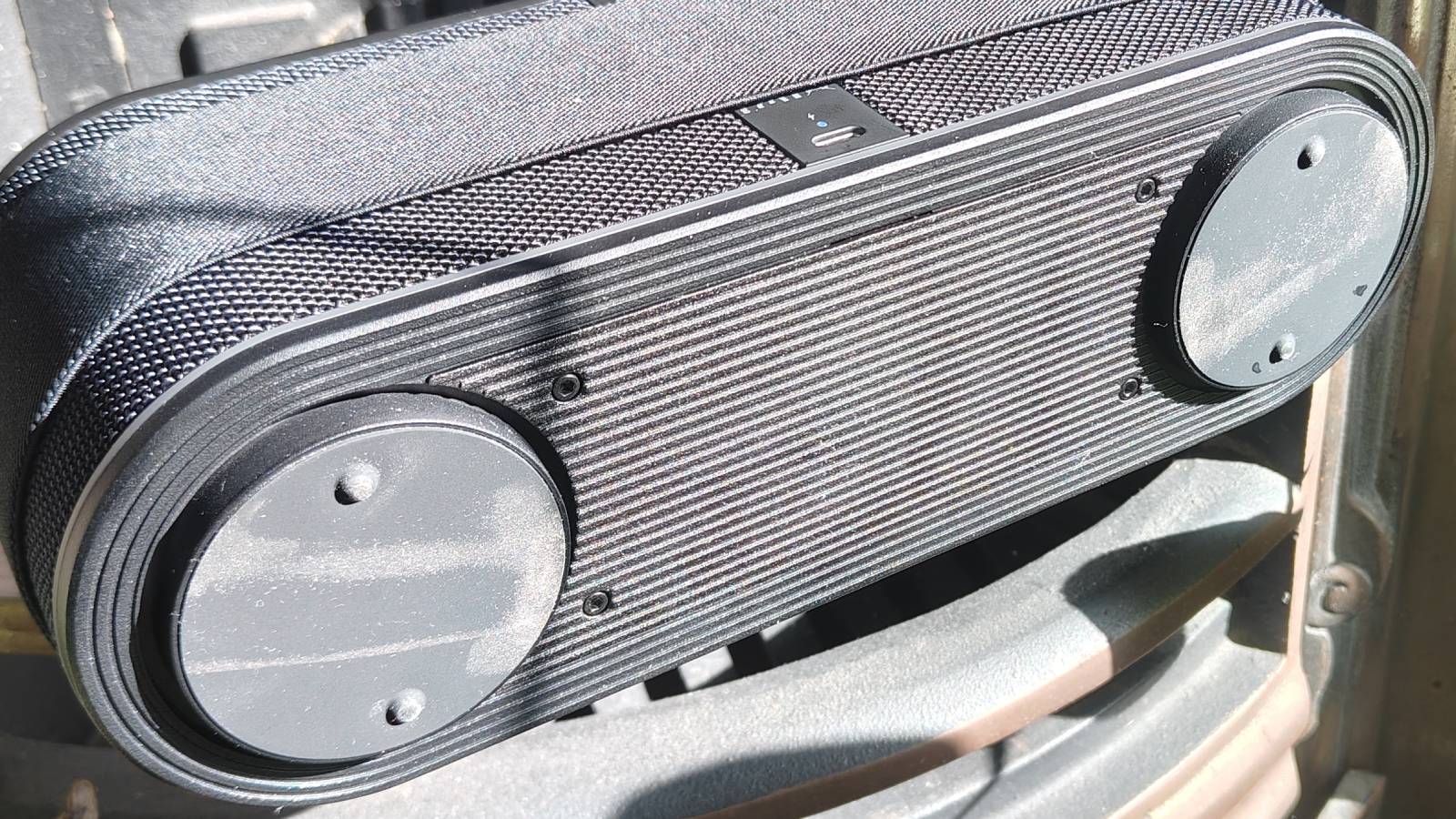 The LG xboom Bounce by a leafy plant on a shelf.