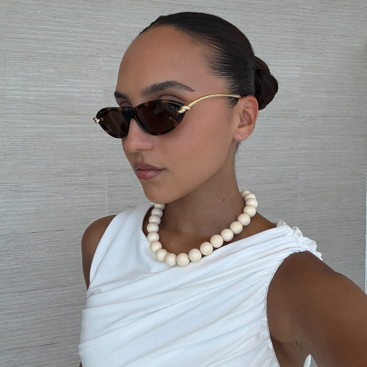Ingrid in sunglasses and a cream-coloured beaded necklace