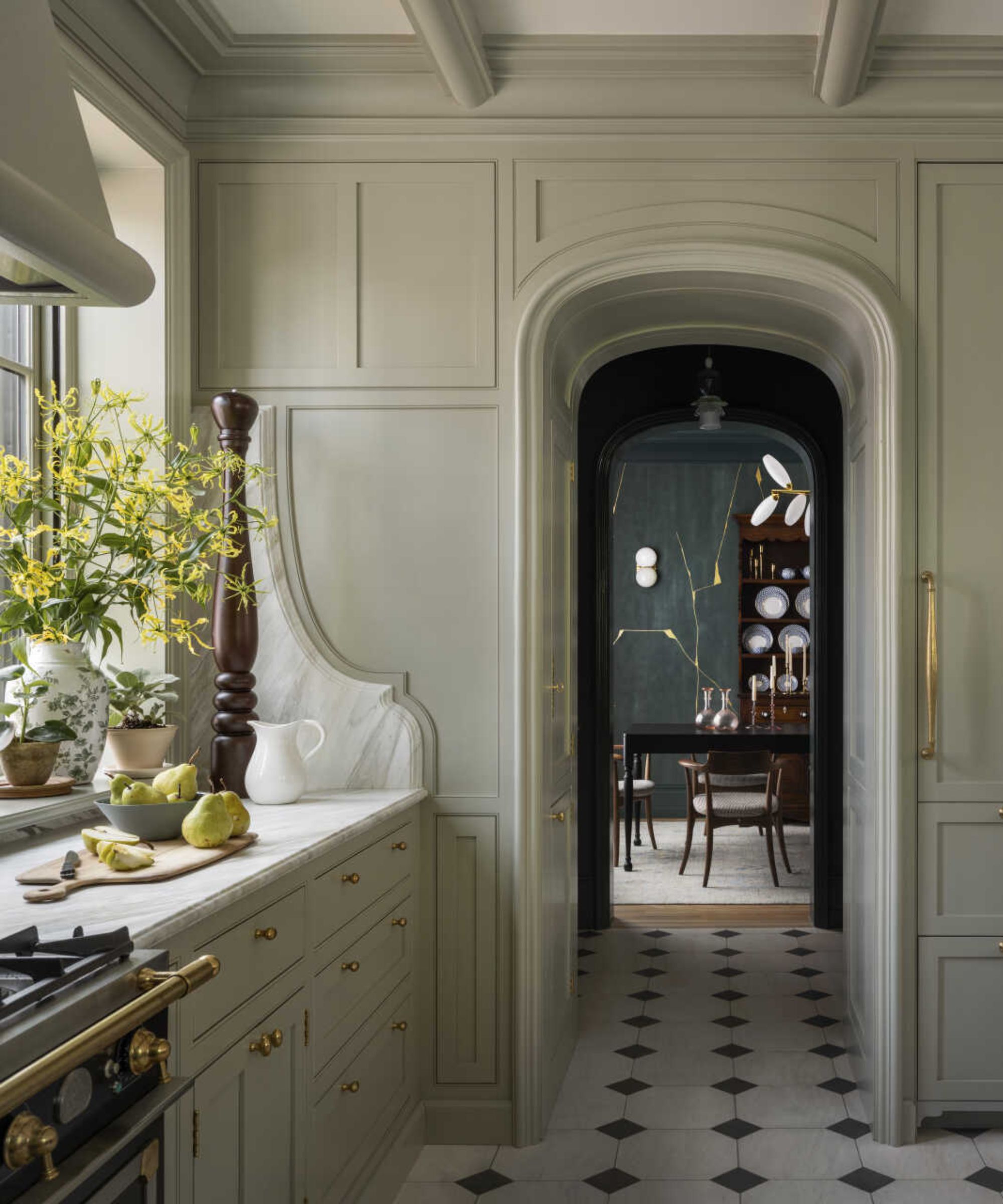 A green kitchen with a marble sidesplash