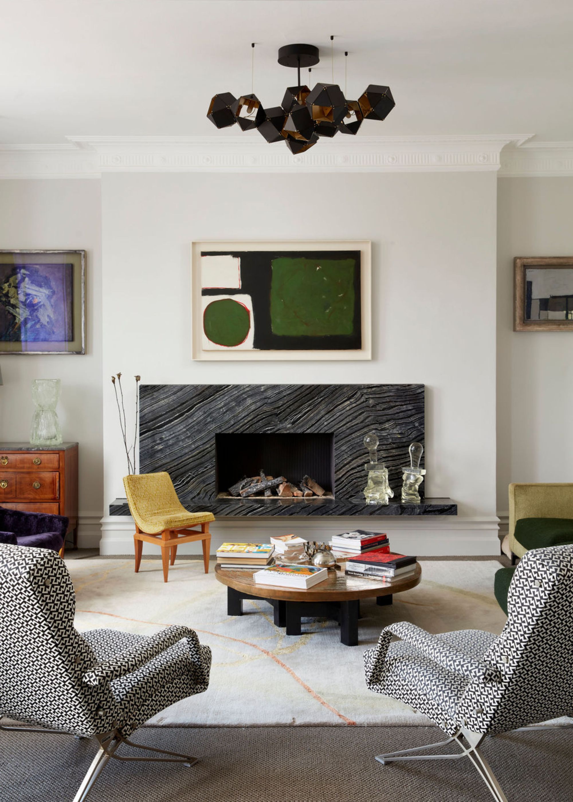 A living room with light gray walls and pops of green and mustard through the furniture and decor.