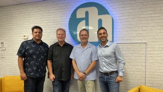 Partners from Sound Marketing West and the Adam Hall Group stand together with smiling faces to announce their partnership.