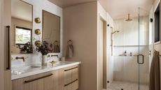 A wood bathroom with white wall tiles and two rectangular mirrors above the double vanity
