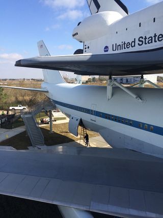 The Independence Plaza exhibit lets visitors stand next to NASA 905 and the shuttle replica, giving a sense of their full scale.