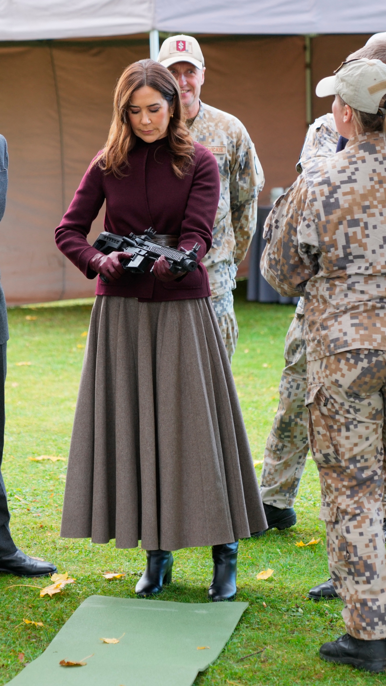 Queen Mary of Denmark holds a gun during their visit at Adazi Gymnasium in Adazi, Latvia, on October 29, 2025
