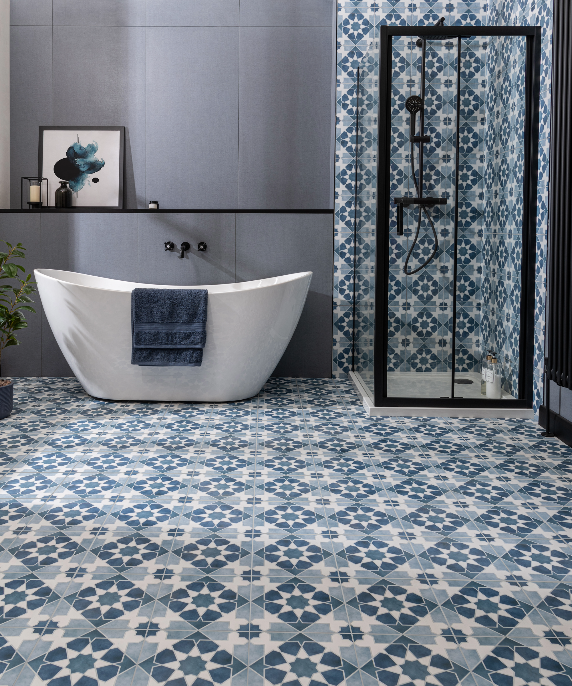 Blue bathroom with patterned floor tiling which is carried up through the shower