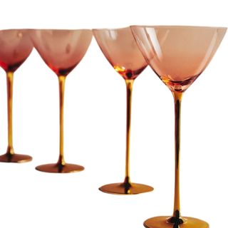 Four dark orange martini glasses in a curved row