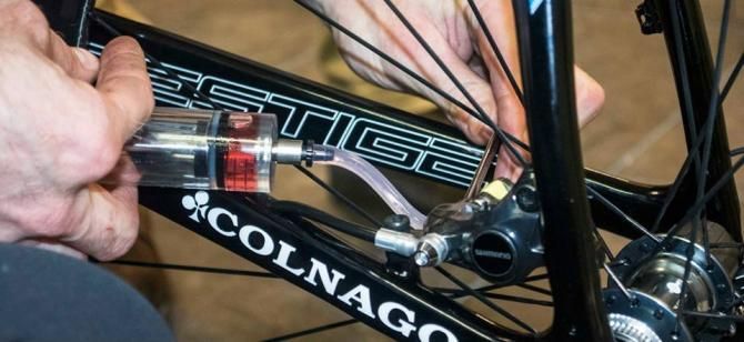 The mechanic loads the fluid into the rear brake