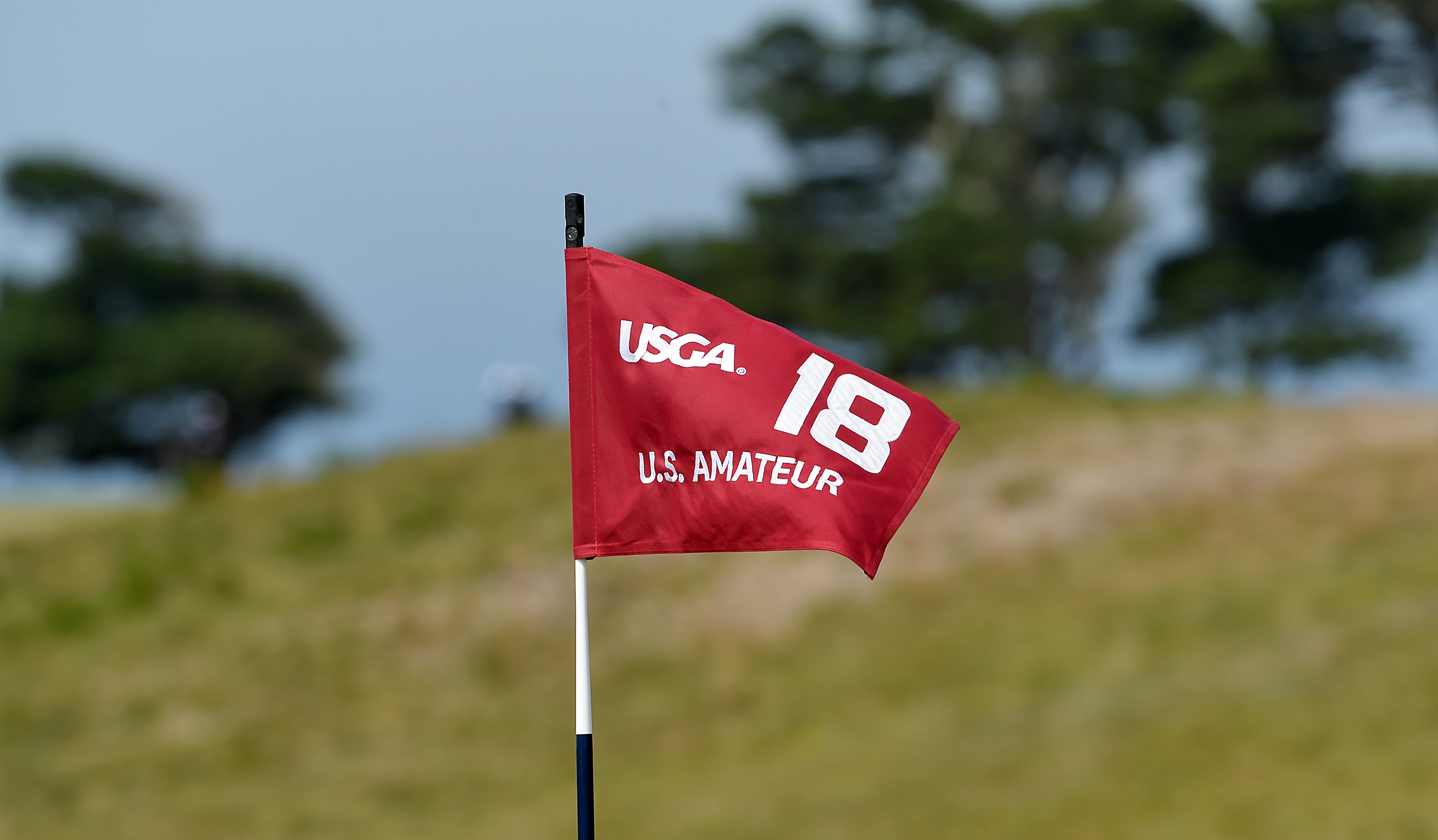 A red no.18 US Amateur flag blowing in the wins
