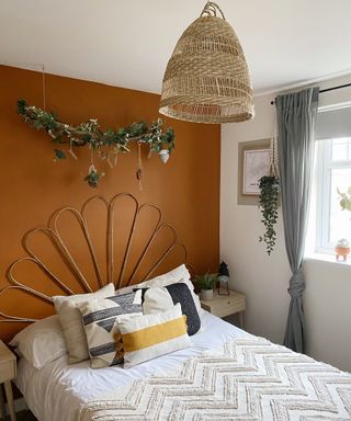 A bamboo DIY headboard in bedroom with terracotta wall paint decor